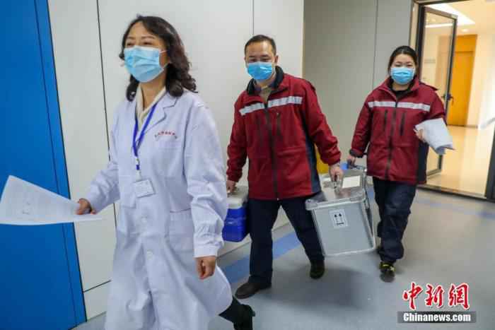 2月4日,武汉市疾控中心检测组工作人员进行病毒检测。武汉市疾控中心是该市首批获准开展新型冠状病毒核酸检测的机构之一。位于该中心病原生物检验所的生物安全二级实验室(P2实验室)则是“绝对禁区”。图为卫生防疫工作人员将送检标本拿进实验室。  探访武汉病原检测实验室:24小时值守让病毒无处遁形